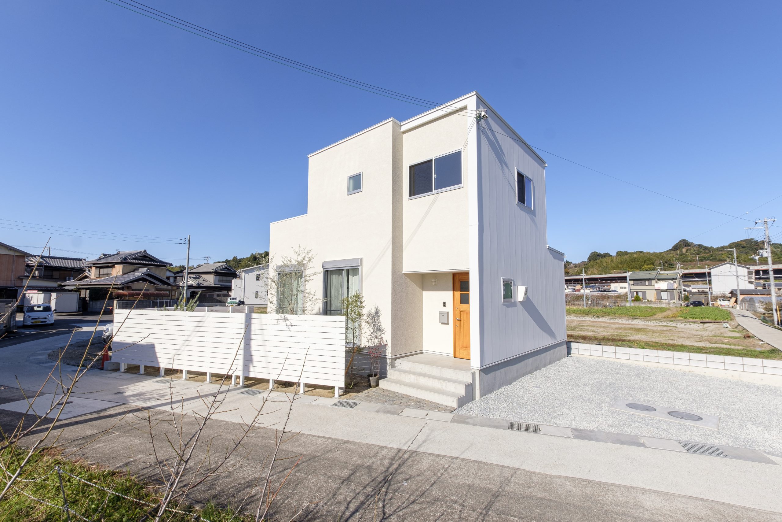 青空に溶け込む白い家